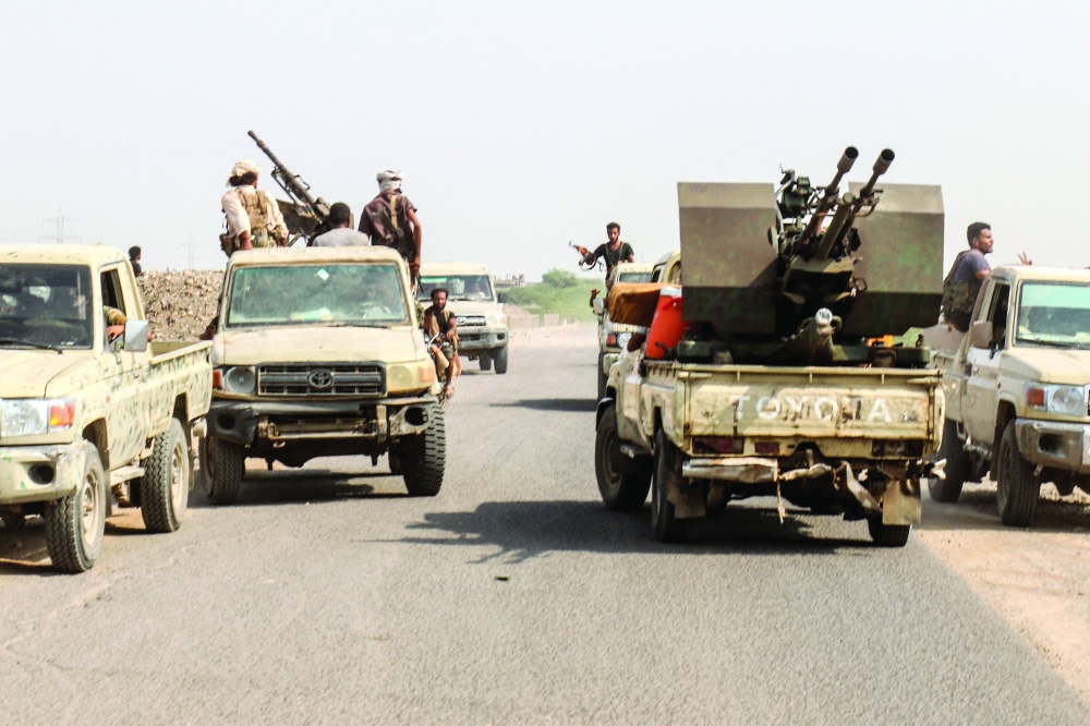 Forces ride in pickup trucks along a road in the Hays district, south of Hodeidah. — AFP