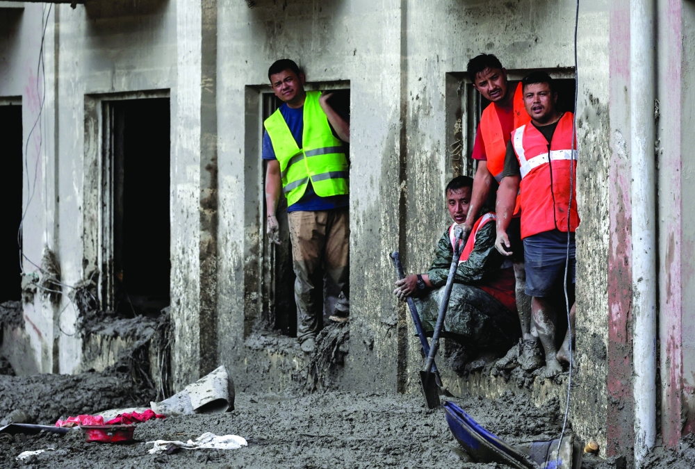 Rescue personnel look through the window of a damaged building in Devighat, Nuwakot district, Nepal. — Reuters