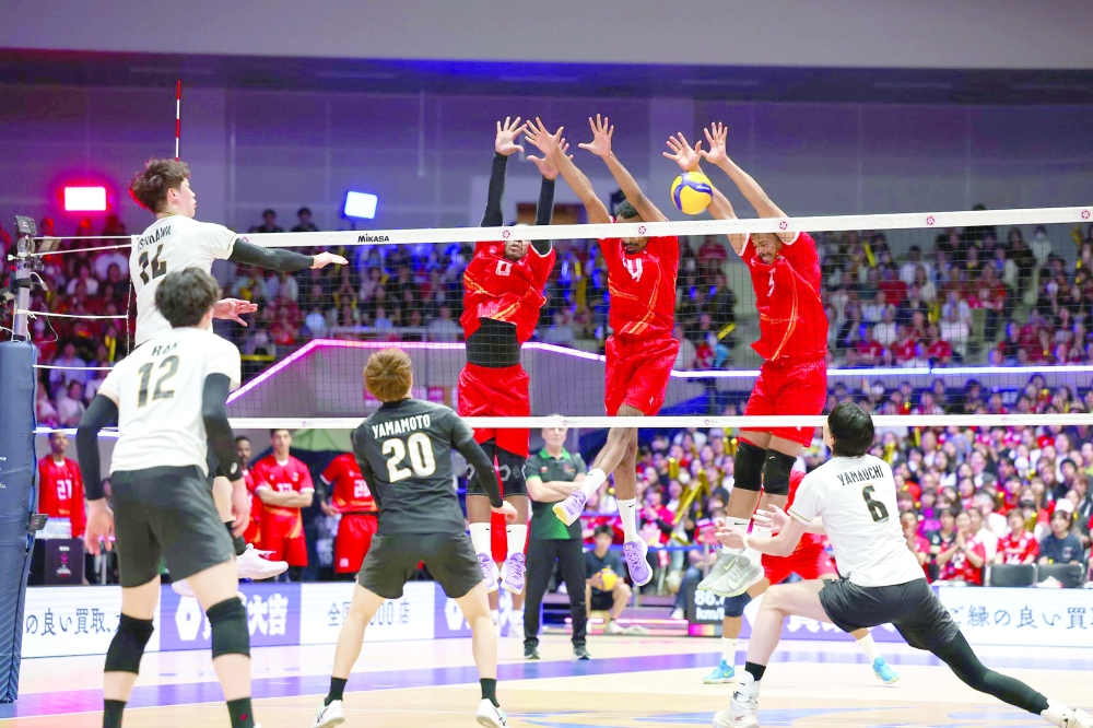 Oman players try to block a smash from Japan.