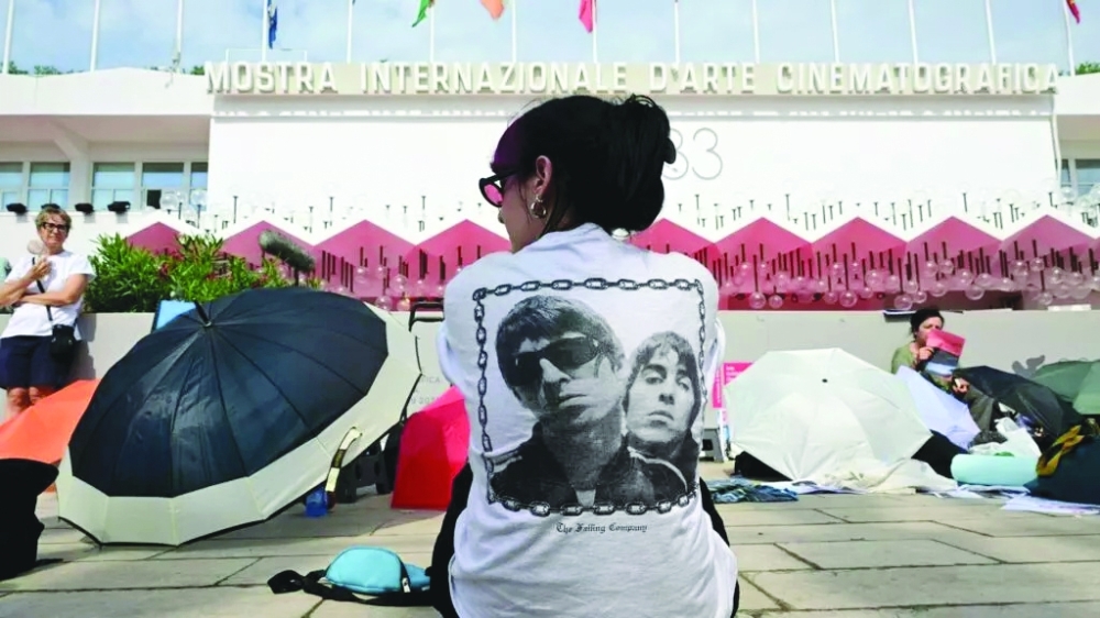 An Oasis fan sits in the sun waiting for the film's premiere— AFP