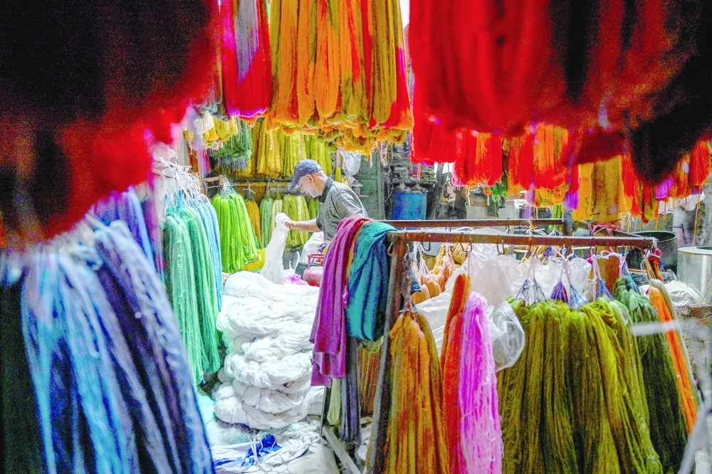 A worker sorts through silk yarns at a traditional dyeing workshop in Srinagar. — AFP