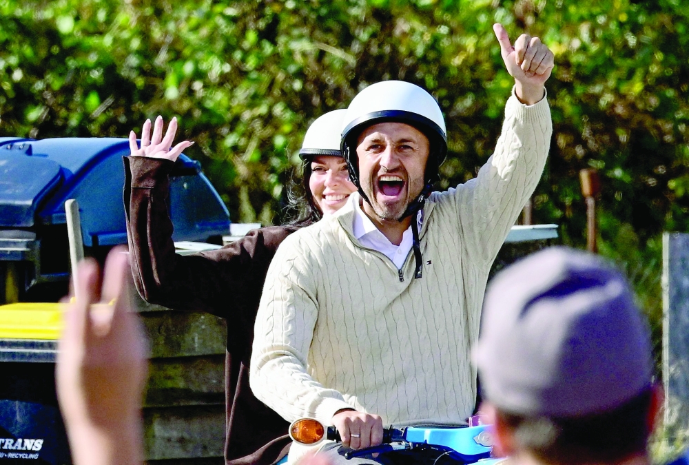 Ulrich Siegmund, top candidate in the Saxony-Anhalt state election for the far-right Alternative for Germany (AfD) party, waves as he and his wife Julia Siegmund arrive on a "Schwalbe" motorbike at the polling station. — AFP