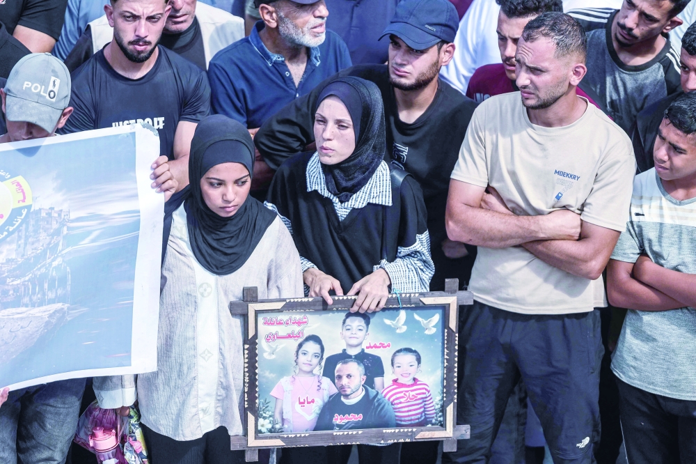 Mourners gather for a mass burial of around 100 Palestinians, including 62 children in Gaza. — AFP