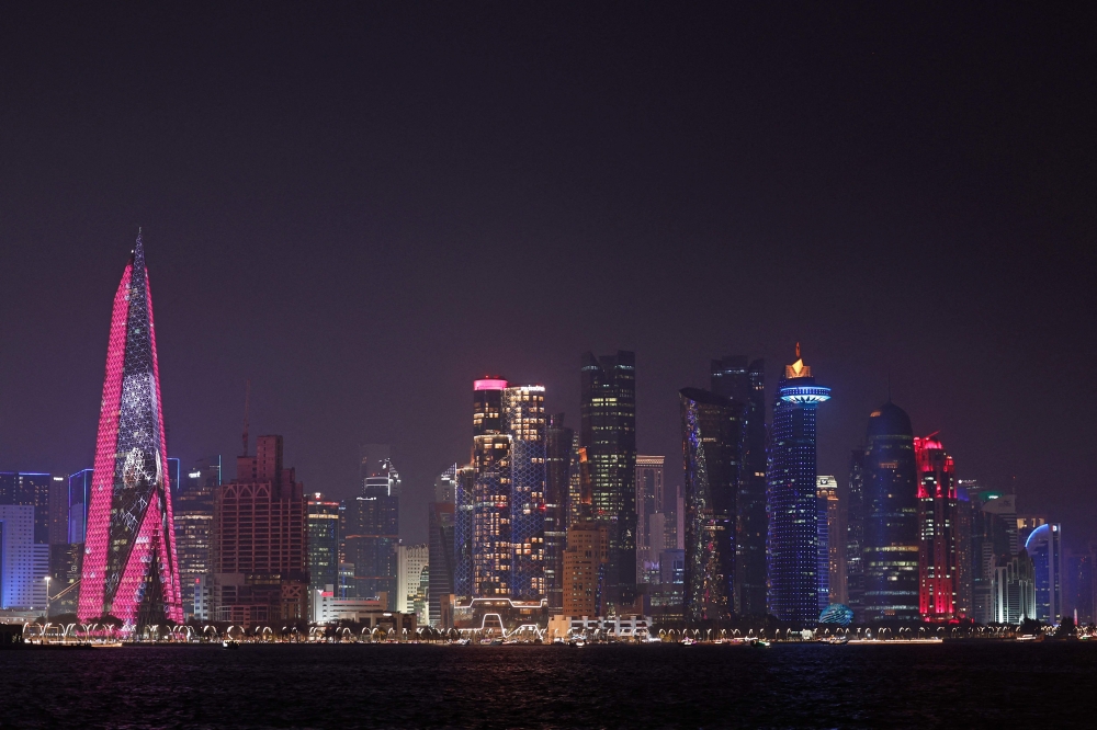 The skyline of illuminated high-rise buildings is seen along the Corniche Promenade in Doha on September 4, 2026