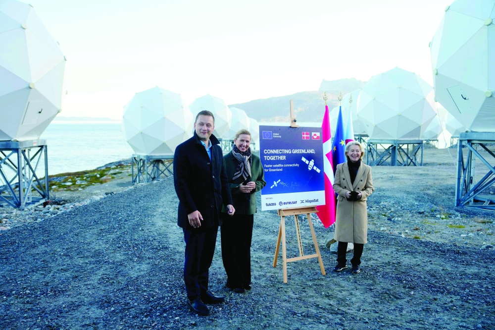 Danish PM Mette Frederiksen (C), President of the European Commission Ursula von der Leyen (R) and Greenland's head of government Jens-Frederik Nielsen (L) visit the company Eutelsat Oneweb in Nuuk. — AFP
