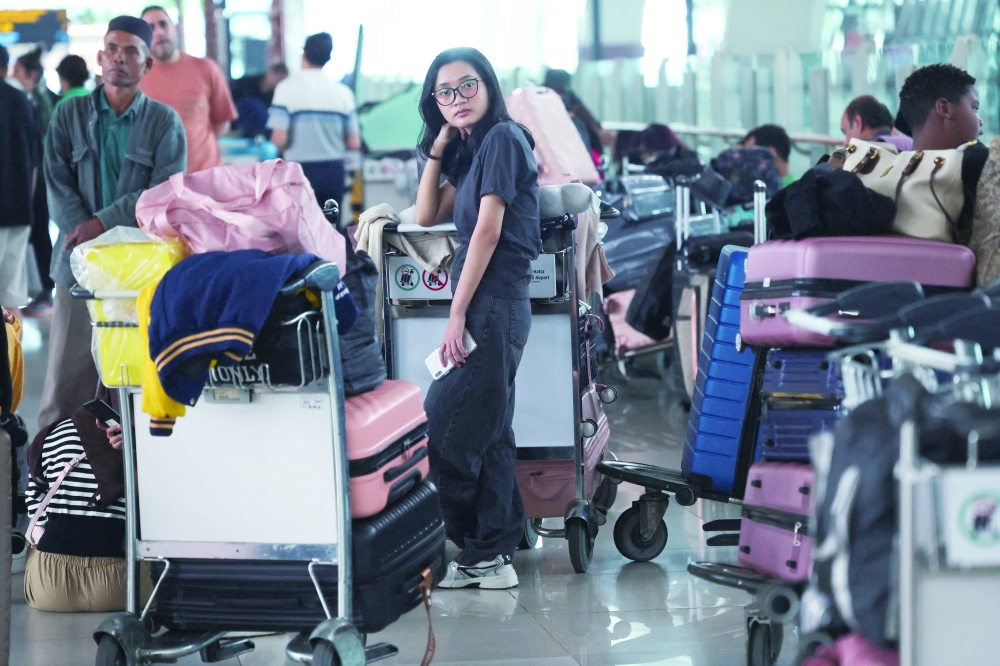 A stranded passenger looks on at the terminal as Soekarno-Hatta International Airport closed its operations in Tangerang, near Jakarta. — Reuters