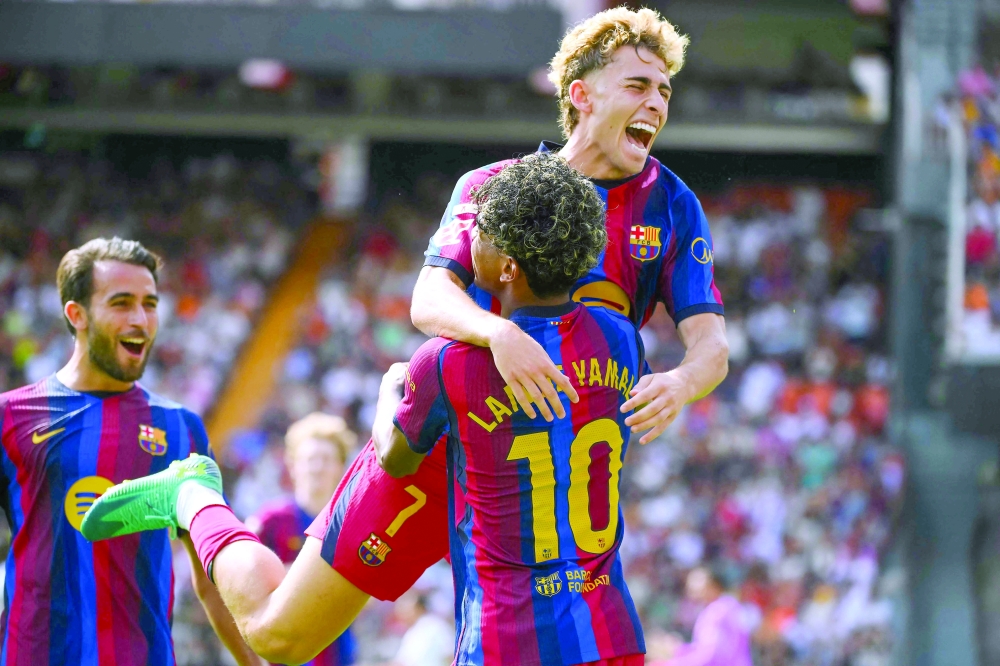 Barcelona's Spanish midfielder Fermin Lopez jumps in celebration with Barcelona's Spanish forward Lamine Yamal after a goal that was eventually disallowed for offside during the Spanish league football match between Valencia CF and FC Barcelona at Mestalla Stadium. — AFP