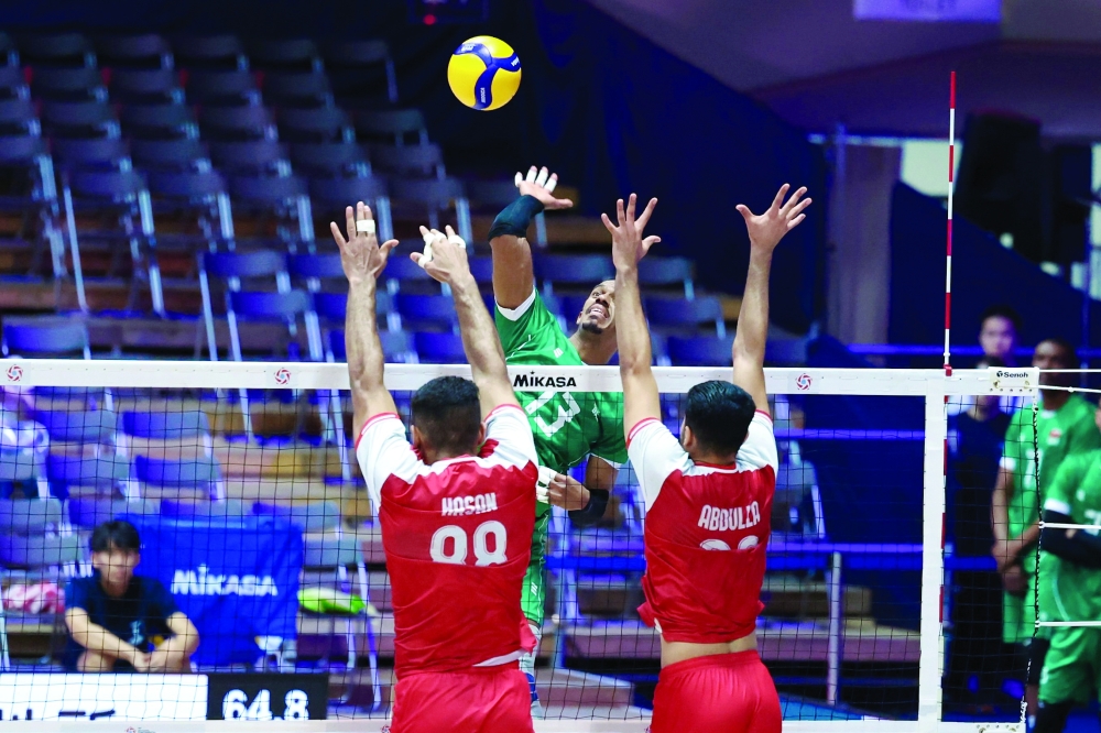 Oman player attempts a smash against Bahrain.