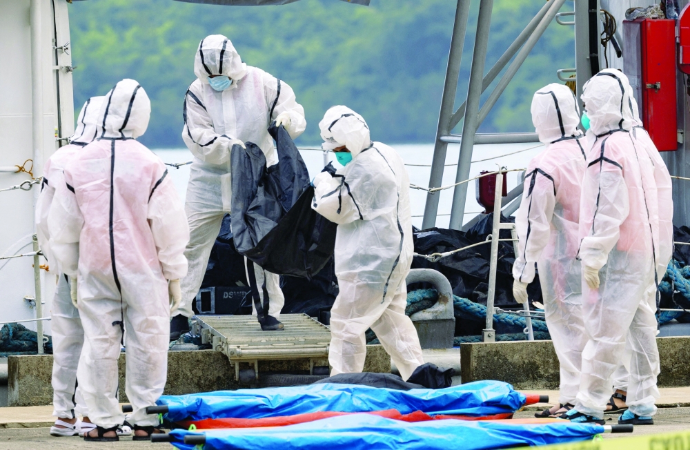 Members of the Philippine Coast Guard carry body bags containing the remains of victims out of a coast guard ship following a fire aboard the MV June Aster ferry off the coast of Palawan, in Coron, Philippines, September 12, 2026. REUTERS/Eloisa Lopez