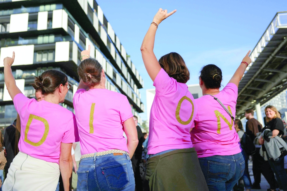 Fans of Celine Dion, wearing a pink tee-shirt bearing on its back the initials of the name of the Canadian singer— AFP