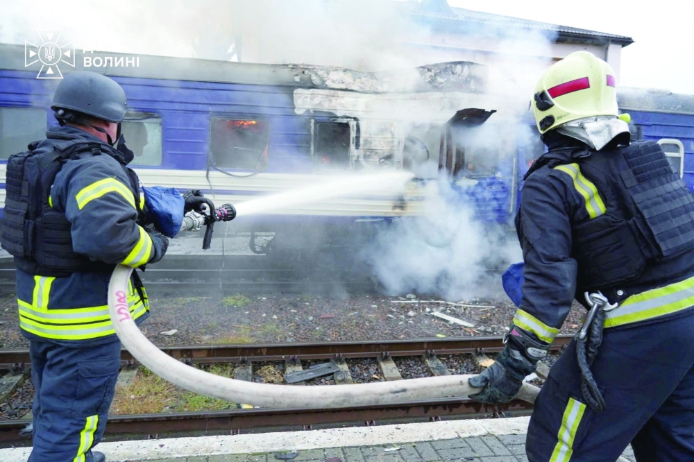 Firefighters extinguish a car of a passenger train hit by a Russian drone strike at a railway station in Lutsk, Ukraine. — Reuters