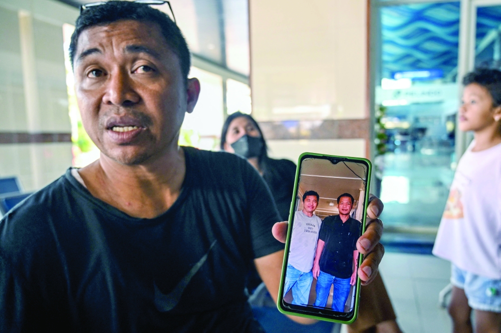 Fredy Manuhua shows a picture of his brother who was a passenger on Virgo Transport 8, which met with an accident en route from East Java to South Kalimantan, in Surabaya. - AFP