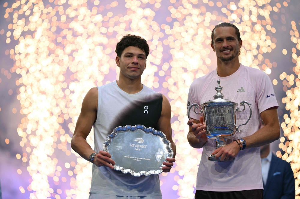 USA's Ben Shelton holds the runner-up trophy next to Germany's Alexander Zverev who holds the winner's trophy  