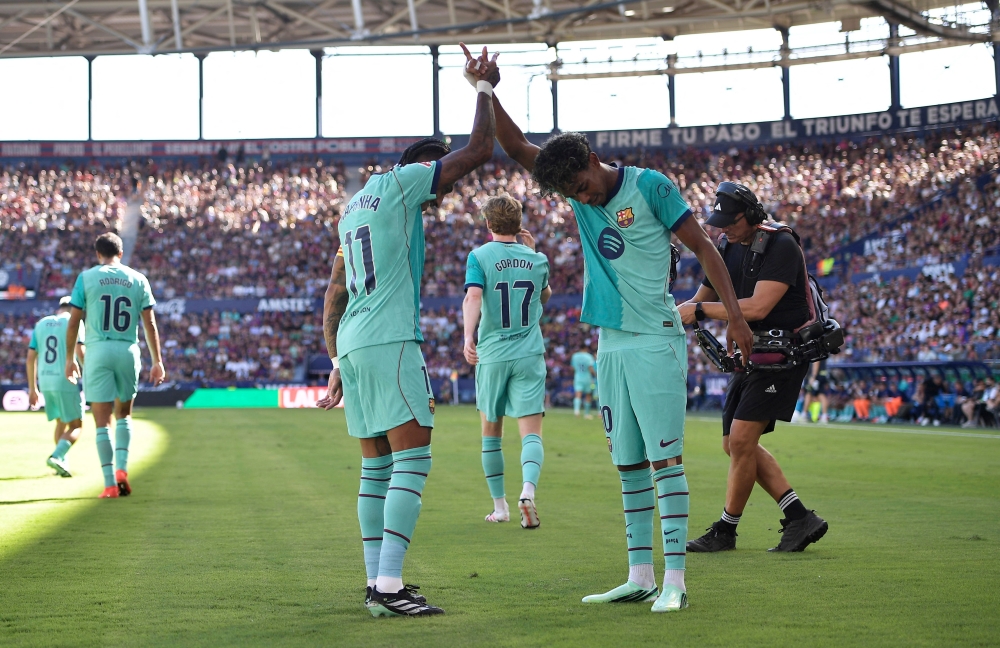  
FC Barcelona's Lamine Yamal celebrates scoring their second goal with Raphinha  