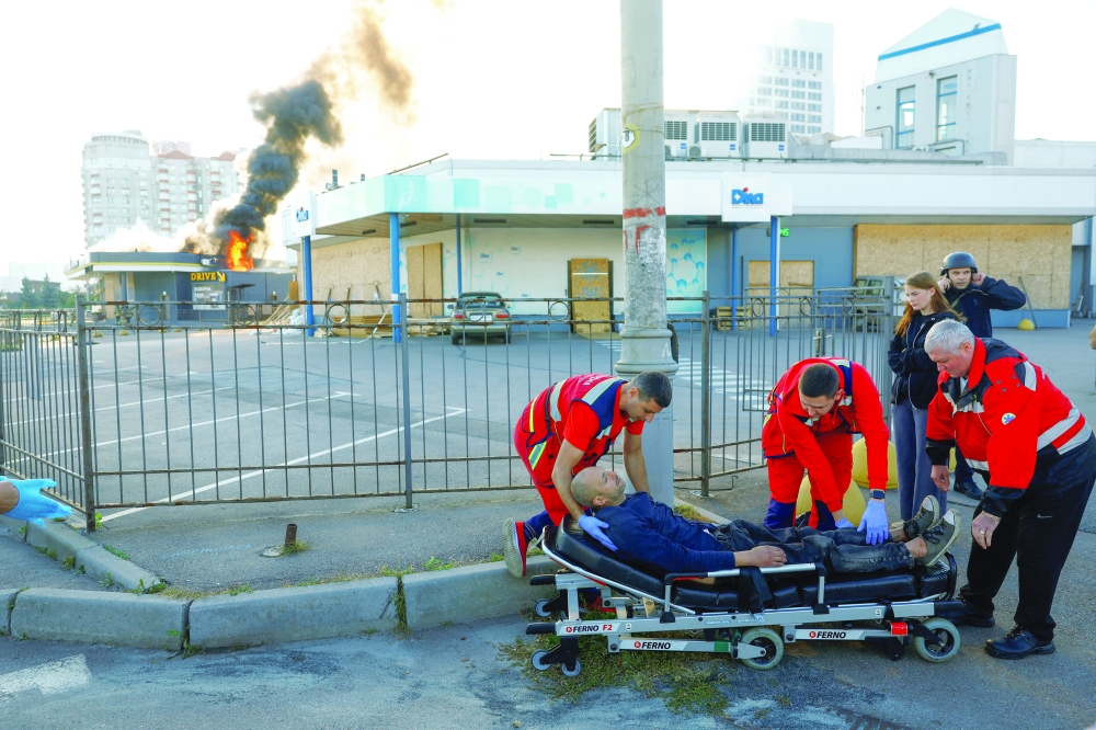 Paramedics prepare to transport a resident injured during a Russian drone strike on a gas station, amid Russia's attack in Kyiv on Tuesday. — Reuters