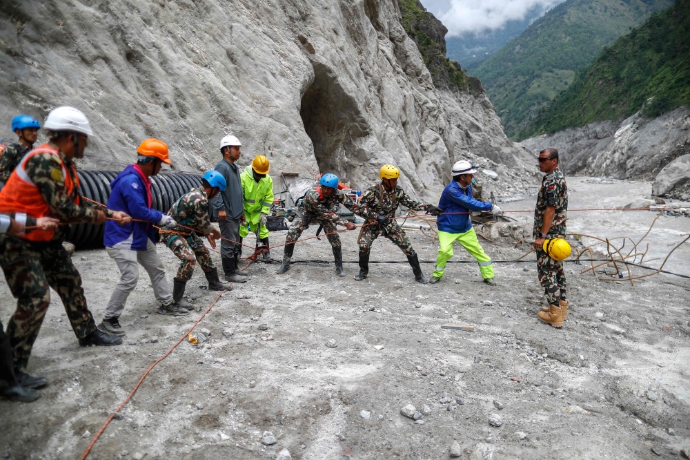 Members of the Nepali Army pull a rope to build a temporary tuin during a search-and-rescue operation at Chilime Hydropower Station tunnel days after deadly flash floods and mudslides in Nepal's Rasuwa district on September 10, 2026.