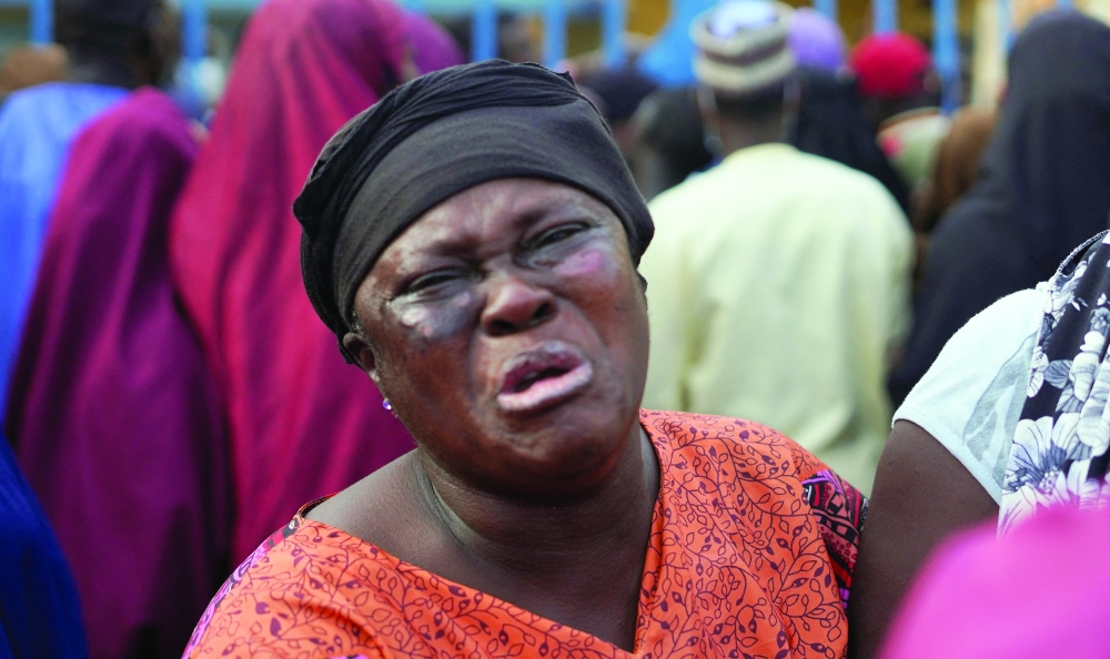 A family member of an illegal mining suspect arrested in mining raids who reportedly died while in detention weeps at Minna General Hospital, in Minna, Niger State, Nigeria. - Reuters