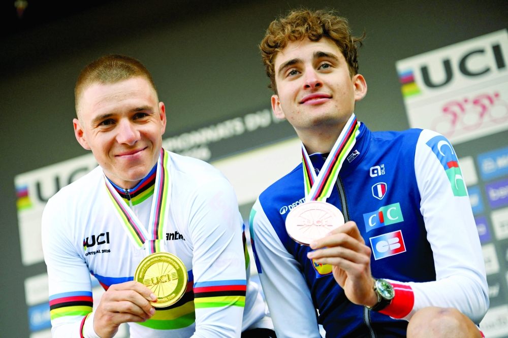First place finisher Remco Evenepoel of Belgium and third place finisher Paul Seixas of France celebrate on the podium after the Men's Elite individual time trial at the 2026 Union Cycliste Internationale. — AFP