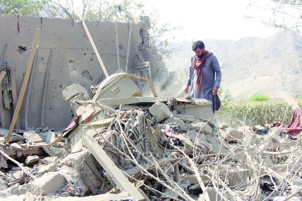 An Afghan resident salvages from the rubble of a destroyed house in the aftermath of a Pakistani air strike in the Nurgal district of Afghanistan's Kunar province. — AFP