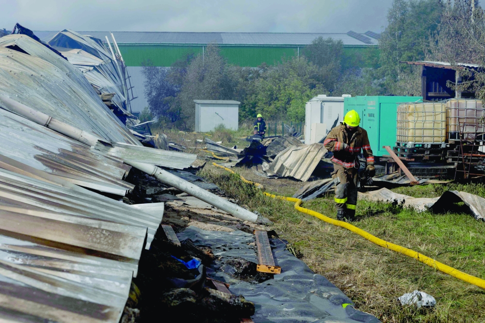 Ukrainian firefighters are working at a destroyed warehouse following a recent Russian drone strike in Kyiv. — AFP