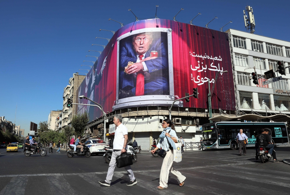 Iranians walk past an anti-Trump billboard along a street in Tehran on September 23, 2026.