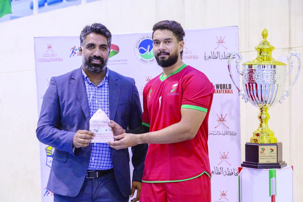 An Oman player receives the player of the match award.
