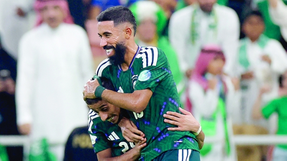 Saudi Arabia's Hammam al Hammami and Nawaf Boushal celebrate after Kuwait's Yousef al Haqan scores an own goal and Saudi Arabia's first in Jeddah. — Reuters