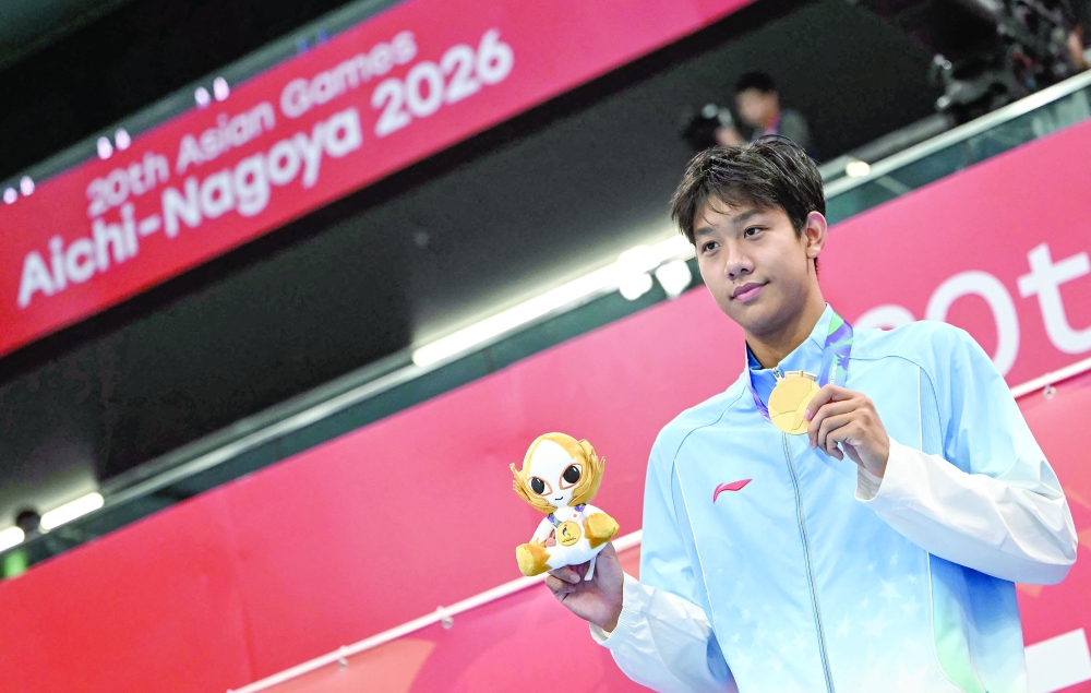 Gold medallist China's Zhang Zhanshuo celebrate on the podium during the victory ceremony of the men's 400m freestyle swimming event during the 2026 Asian Games at the Tokyo Aquatics Centre in Tokyo on September 25, 2026.  (Photo by ANDREW CABALLERO-REYNOLDS / AFP)
