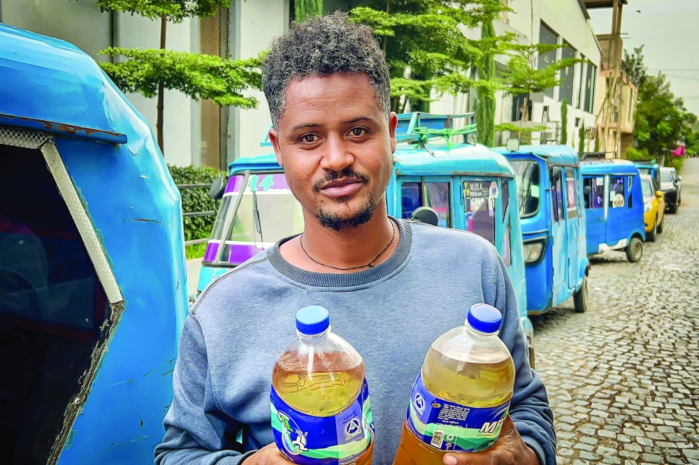 Gebretsadik Abraha poses while carrying bottles of fuel amid fears of shortages and rising prices in Mekelle as fresh fighting erupted between Tigrayan rebels and Ethiopia's federal government. - AFP