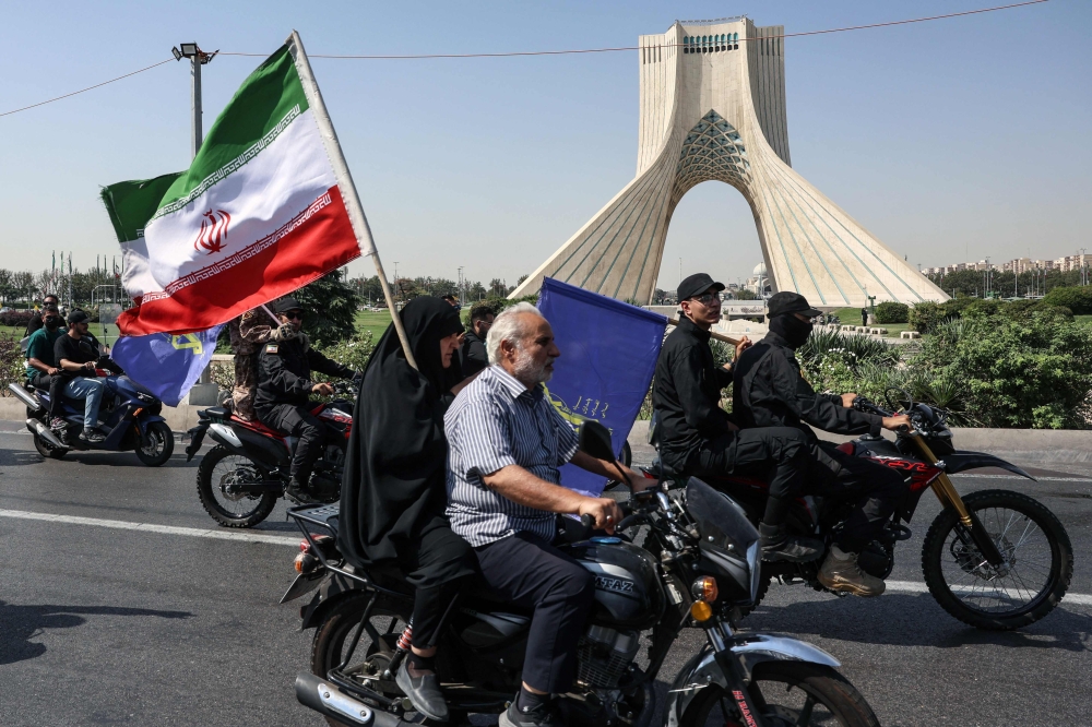 Members of Iran's Basij paramilitary force take part in a motorcycle rally to support the government in Tehran on Friday. — Reuters