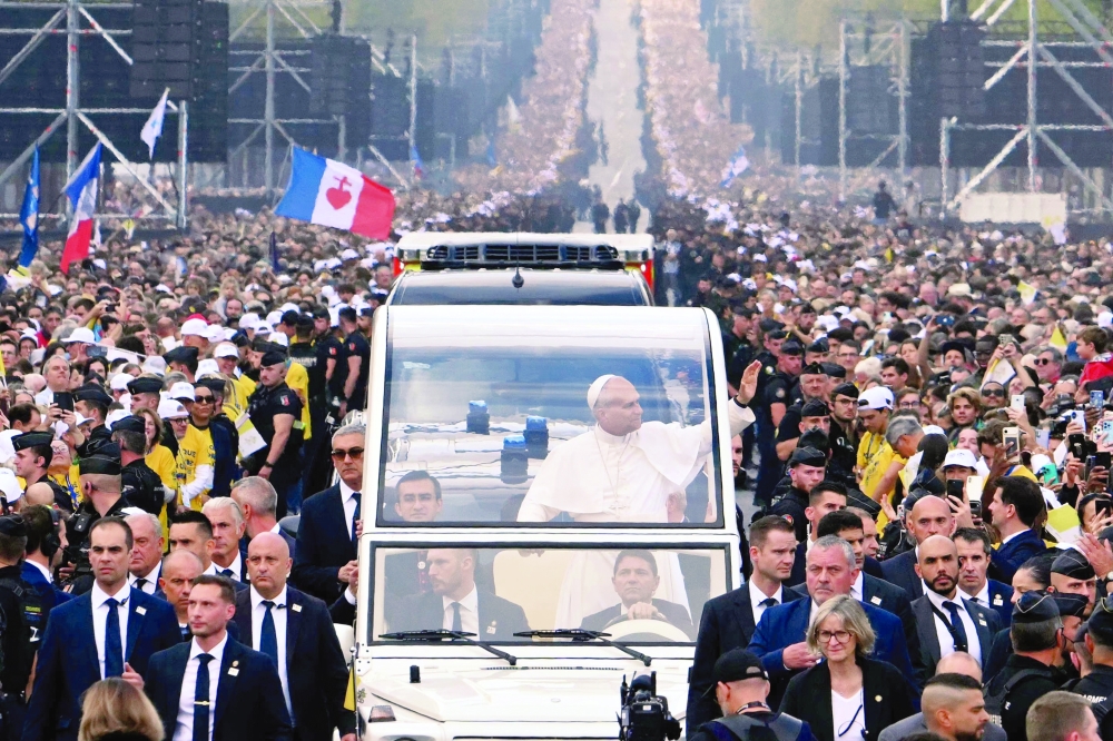 Pope Leo XIV waves to the crowd from the Papamobile as he rides down the Champs-Elysees Avenue on his way to the Place de la Concorde, Paris. — AFP