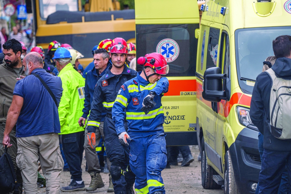 Emergency personnel work after an old building partially collapsed in the Plaka area of central Athens. — AFP
