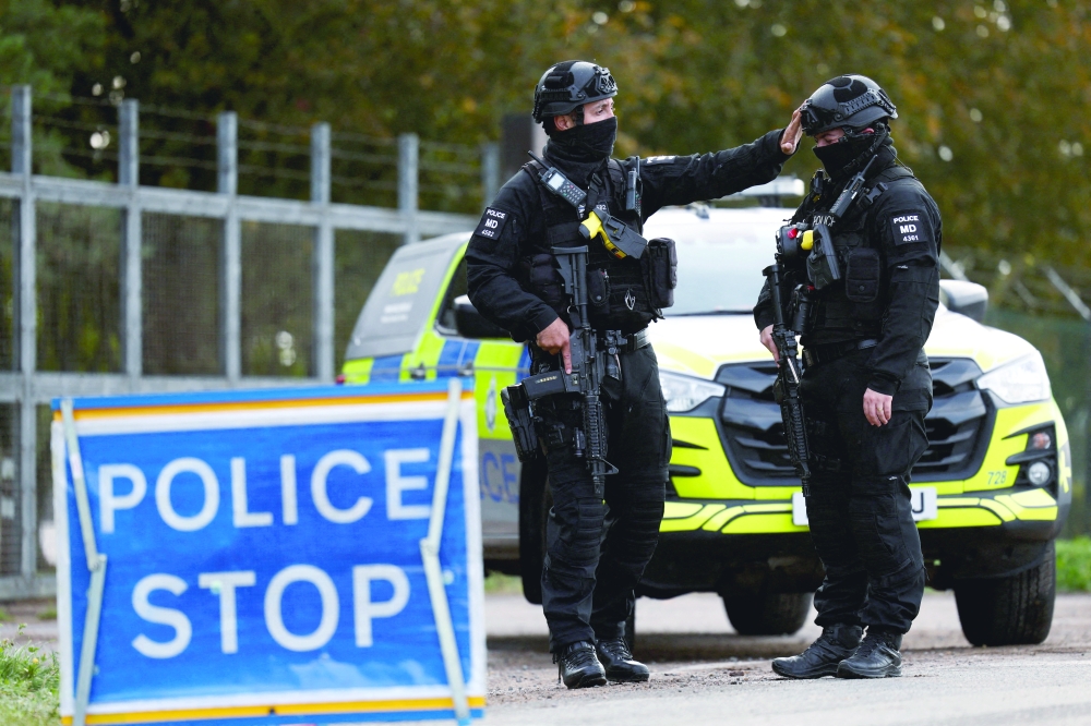 Armed police officers work on a road outside the perimeter of the RAF Fairford airbase, Britain. — Reuters 