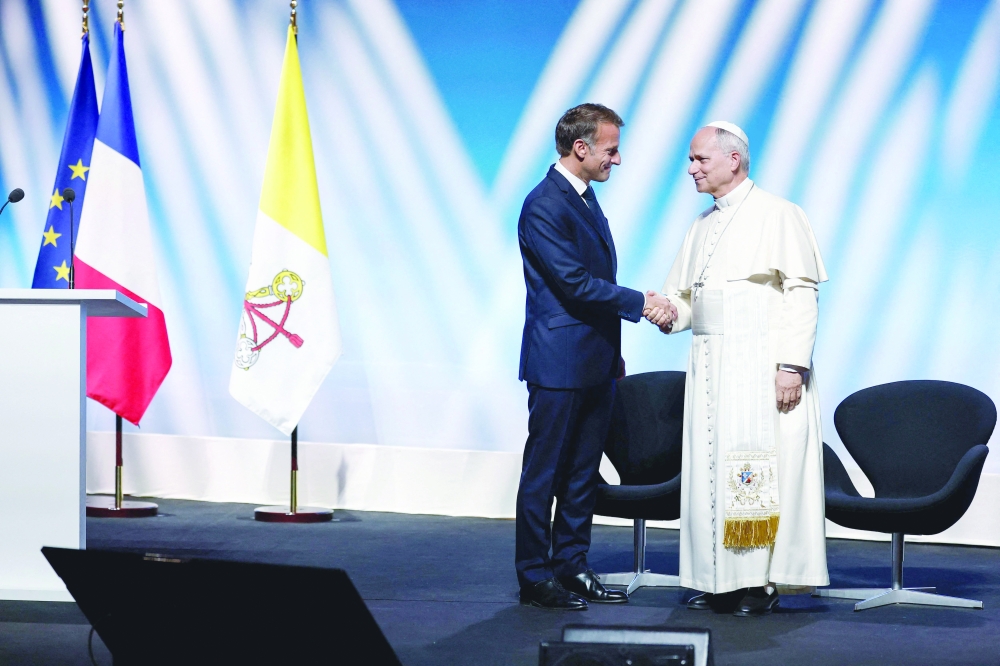 Pope Leo XIV (R) and French President Emmanuel Macron (L) shake hands during a meeting at the Robert Schuman Conference Centre in Metz. — AFP