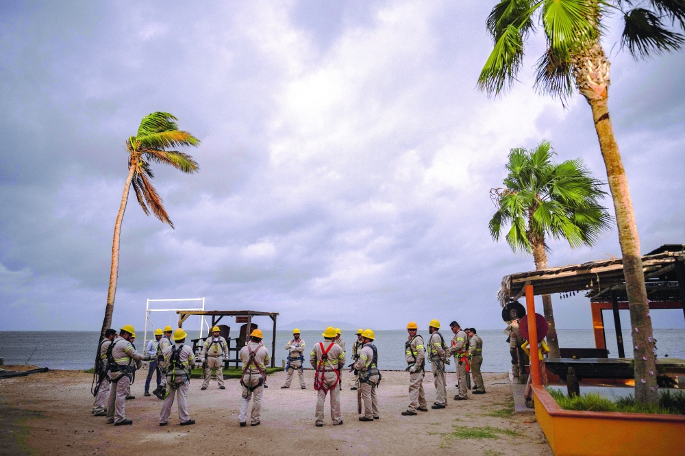 Workers from the electricity company gather for a planning meeting in Puerto San Carlos, Baja California Sur, Mexico. — AFP