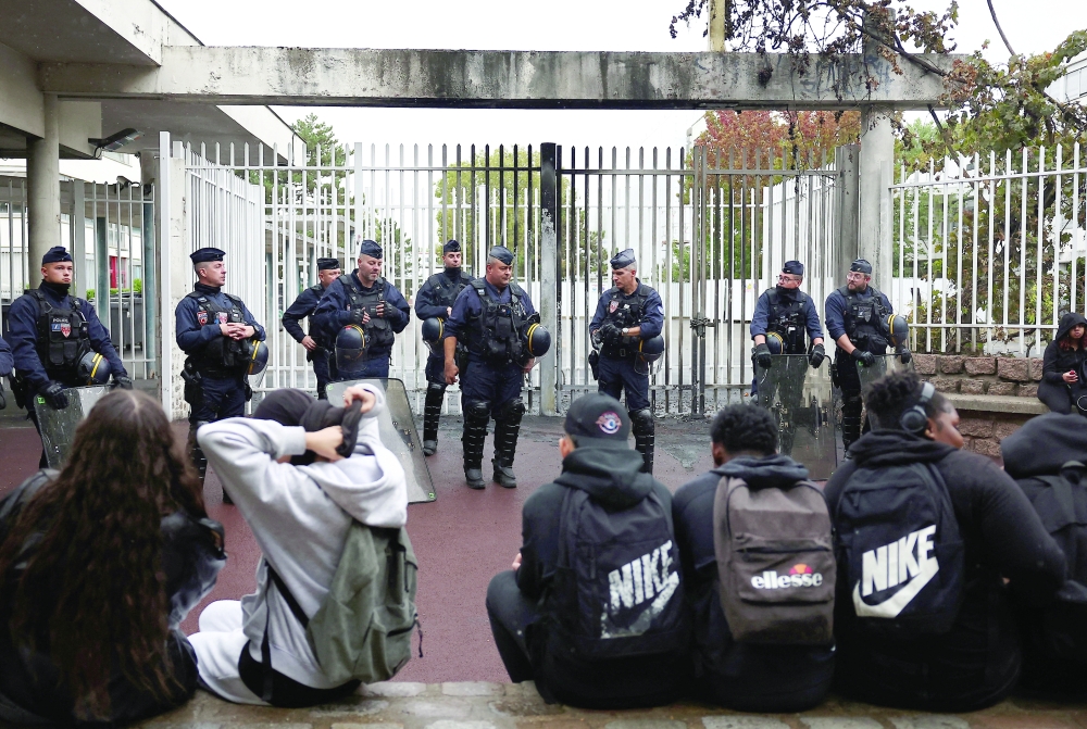 French CRS riot police stand guard in front of the entrance of the Lycee Paul Eluard high school in Saint-Denis, near Paris. — Reuters 