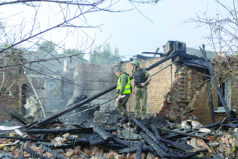 Investigators search the rubble for the remains of two residents in Kyiv. — Reuters 