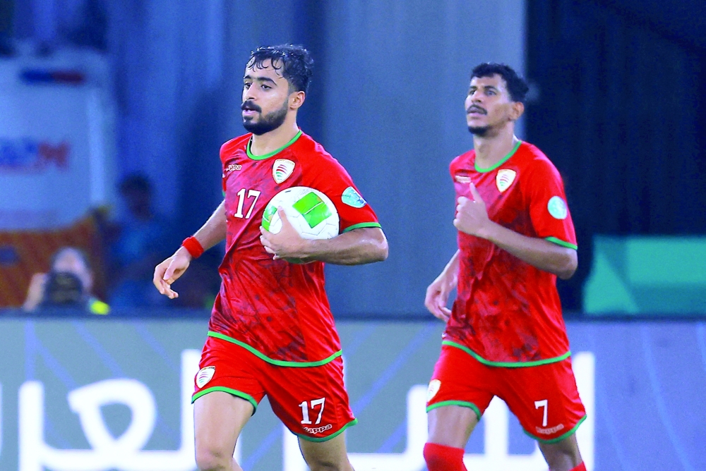 Oman's Nasser al Rawahi celebrates scoring their second goal. — Reuters