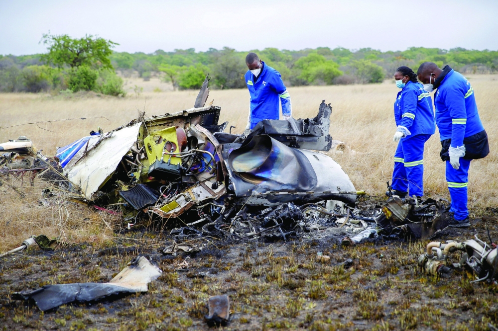 Officials work at the site of a helicopter crash at Kudenga Farm in the Marondera rural area, east of Harare, Zimbabwe. — Reuters