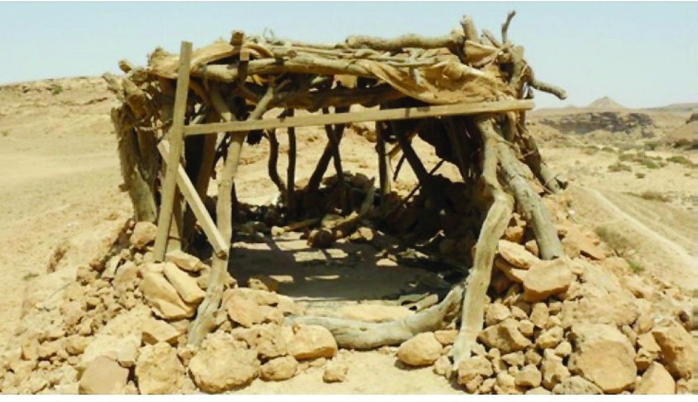 The covered part of the house with a stone wall about a metre high and the roof structure is formed by wooden posts that support horizontal beams.