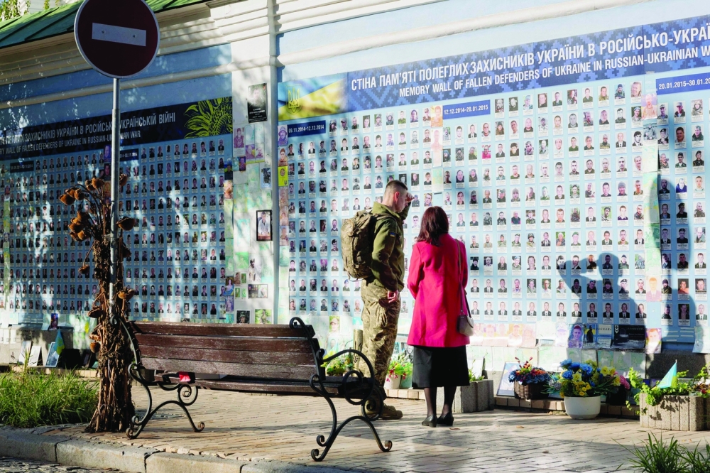 A Ukrainian soldier looks at the Wall of Remembrance of the Fallen for Ukraine in central Kyiv. — AFP