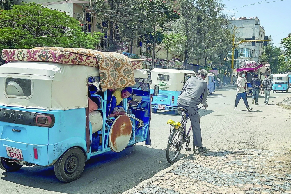 Tuk-tuk drivers transport residents' belongings amid fears of looting as residents and fighters leave the city of Mekelle. — AFP