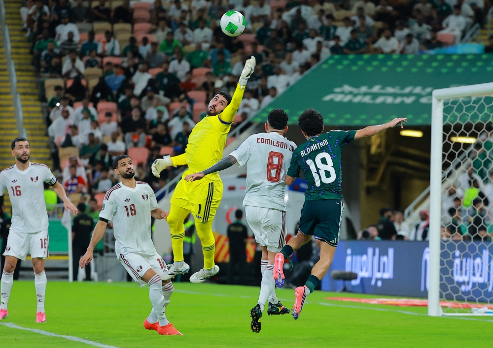 Qatar's Meshaal Ibrahim Abunada and Edmilson Junior in action with Saudi Arabia's Mohammed Hamad al Qahtani. — Reuters