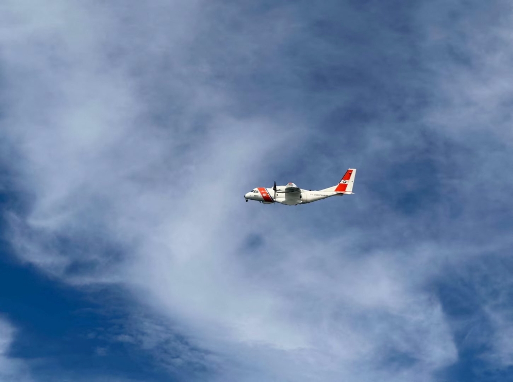 A US Coast Guard plane searches for people after it found debris from a medical transport aircraft off the shore of Massachusetts' Nantucket island
