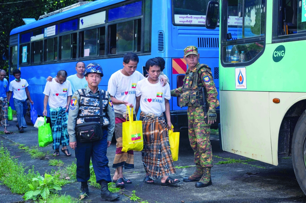 Myanmar migrants repatriated from Malaysia arrive at a temple in Thanlyin, Myanmar, on Sunday. — AFP