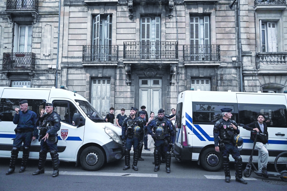 Riot policemen stand alert securing the area in Bordeaux, south-western France. — AFP