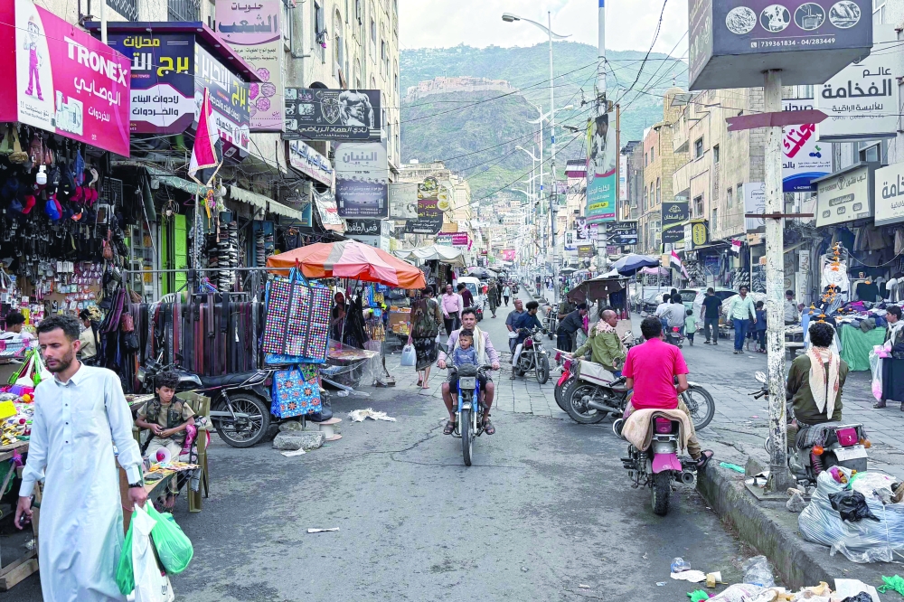 People walk through a market area in Taiz on Sunday. More than 70 people have been killed over the past day by fighting in and around the western Yemeni province of Taiz, sources from both sides said, following days of clashes between Ansar Allah and government forces. — AFP