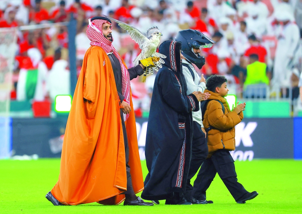 A falconer carries a bird of prey on the pitch at half-time during the final. — Reuters
