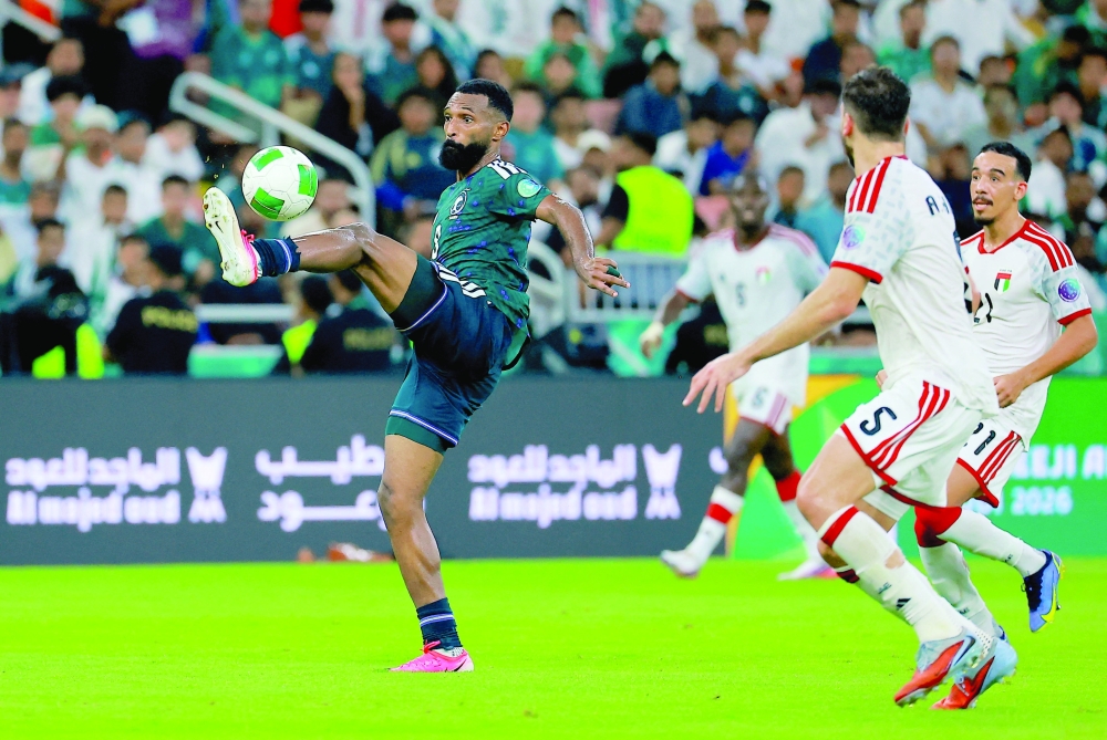 Saudi Arabia's Firas al Buraikan in action with United Arab Emirates' Ala Zhir during the Gulf Cup final at King Abdullah Sports City Stadium, Jeddah. — Reuters