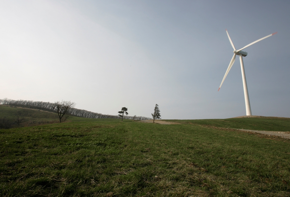 The rotor of a wind turbine turns round at a wind power plant on top o